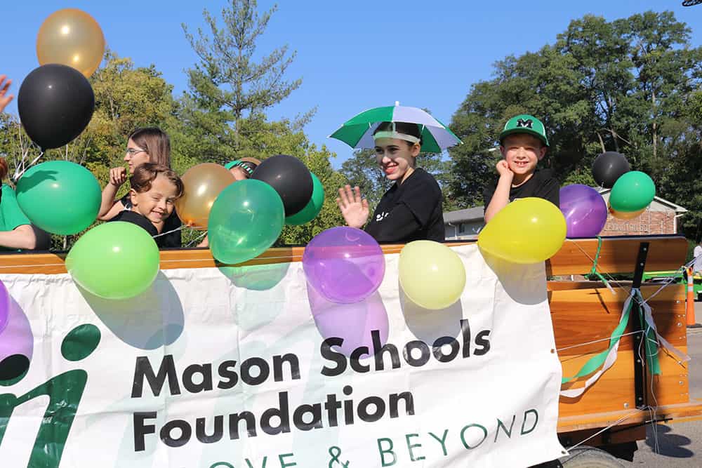 Mason students at heritage Mason parade holding MSF Grants banner