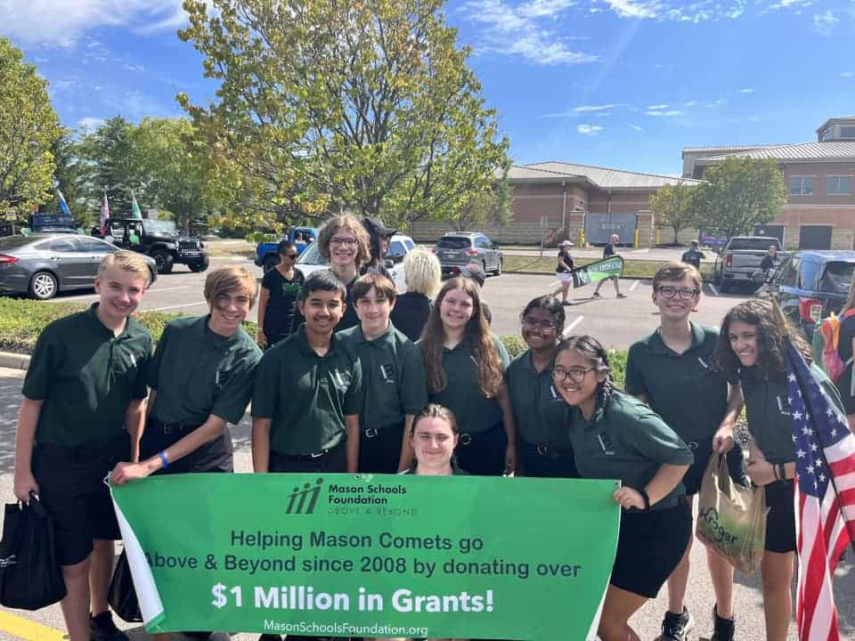 Mason students at heritage Mason parade holding MSF Grants banner