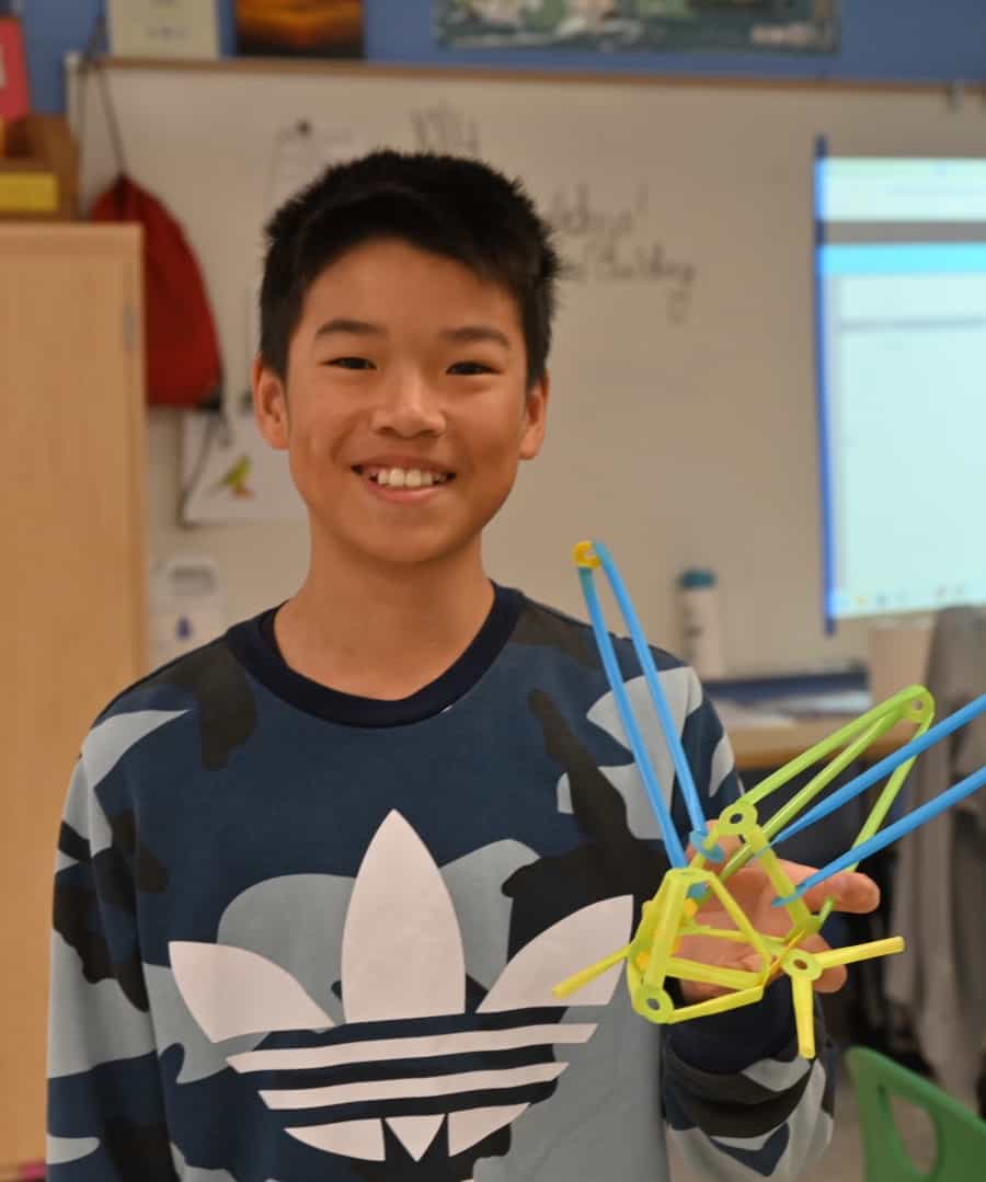 Student displaying sustainable strawbot